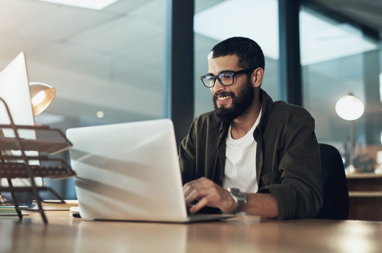 shot-of-a-young-businessman-using-a-laptop-during-a-late-night-in-a-modern-office